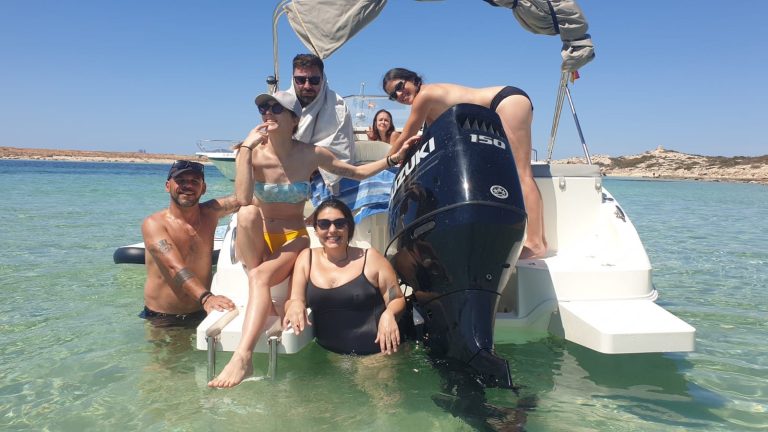 Grupo de personas disfrutando en la popa del barco en aguas cristalinas Un día insuperable con amigos